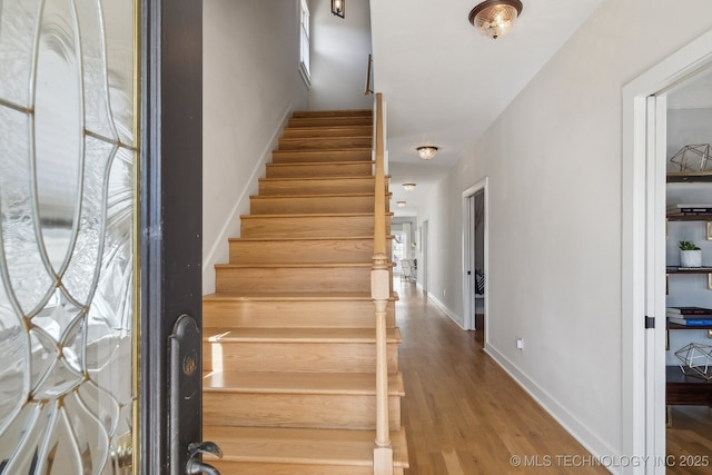 stairs with baseboards and wood finished floors