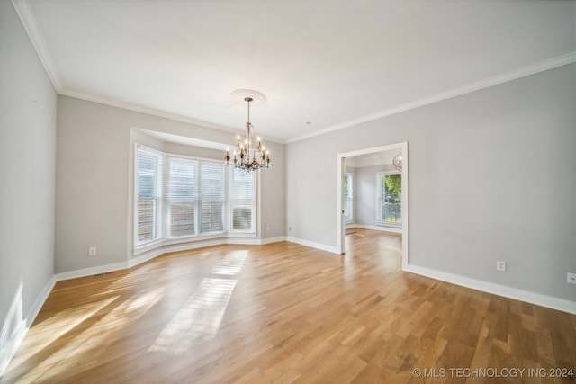 unfurnished room featuring a chandelier, light wood-type flooring, and a wealth of natural light