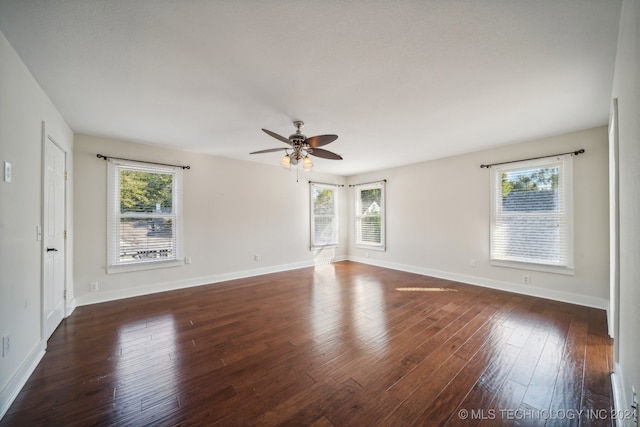 empty room with dark hardwood / wood-style floors and ceiling fan