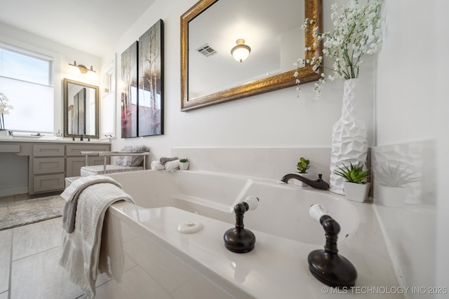 bathroom with vanity, a garden tub, and visible vents