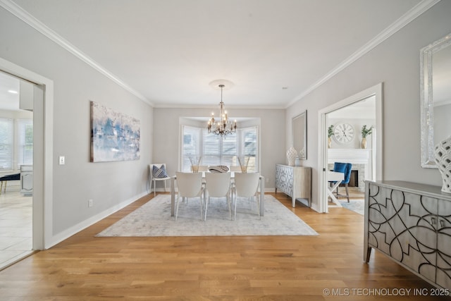 dining space featuring an inviting chandelier, light wood-type flooring, and ornamental molding