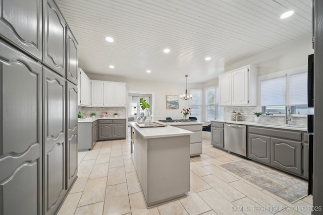 kitchen featuring gray cabinets, a sink, light countertops, dishwasher, and a center island