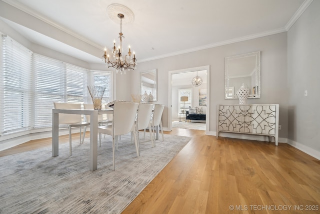 unfurnished dining area with baseboards, an inviting chandelier, wood finished floors, and crown molding