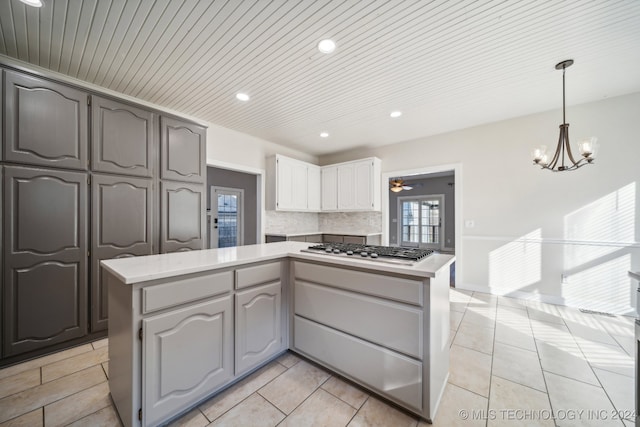 kitchen featuring decorative backsplash, stainless steel gas cooktop, decorative light fixtures, white cabinets, and gray cabinets