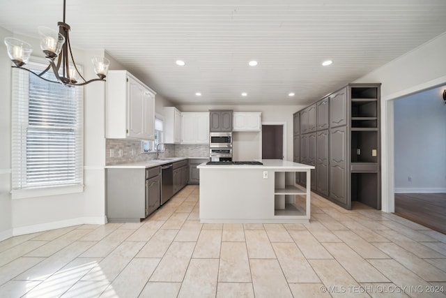 kitchen with a center island, stainless steel appliances, white cabinetry, and a wealth of natural light