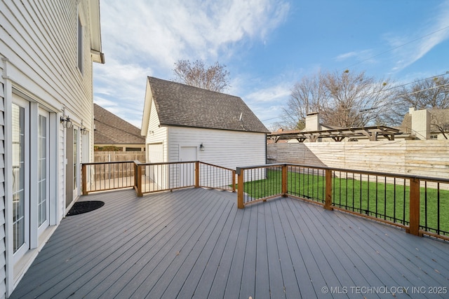 wooden deck with a yard, an outdoor structure, and a fenced backyard