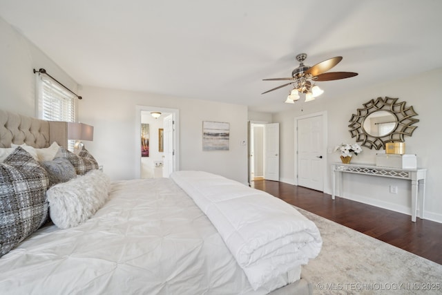 bedroom with connected bathroom, baseboards, wood finished floors, and a ceiling fan