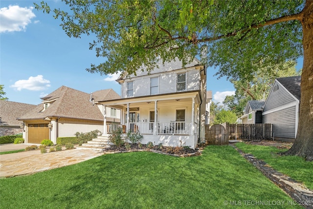 traditional style home featuring a front lawn, fence, covered porch, driveway, and an attached garage