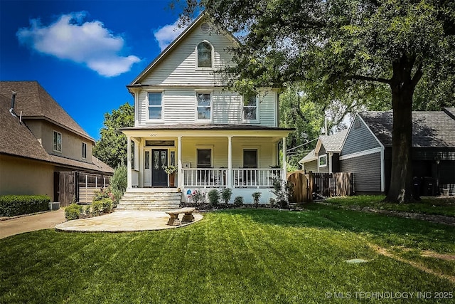 view of front of home featuring a porch, a front yard, and fence