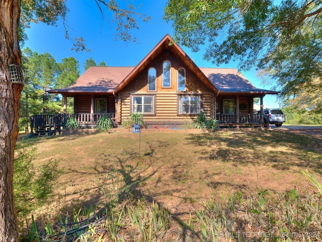 log cabin featuring a front lawn and covered porch