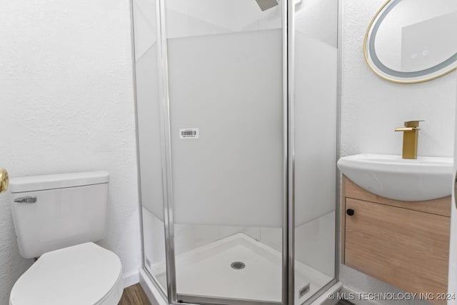 bathroom with walk in shower, vanity, and toilet