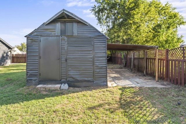 view of outbuilding featuring a yard and a carport