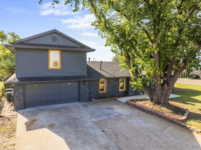 front facade featuring a garage and central AC unit