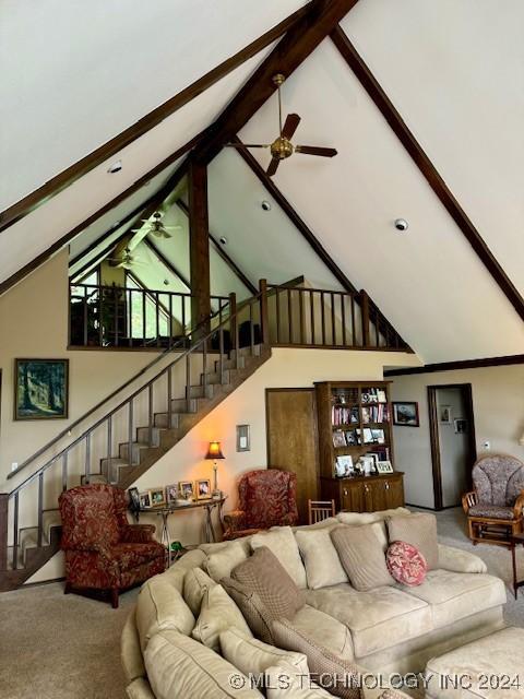 living room with ceiling fan, carpet floors, high vaulted ceiling, and beamed ceiling