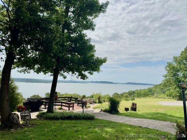 view of home's community with a water view and a lawn