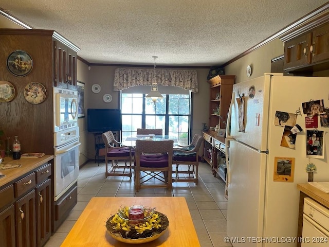 kitchen featuring dark brown cabinetry, butcher block countertops, and white appliances