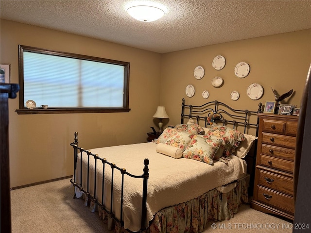 bedroom with carpet floors and a textured ceiling