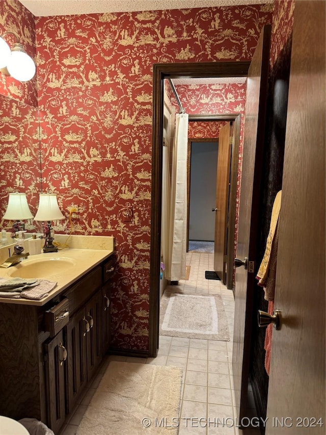 bathroom with tile patterned floors, vanity, and a textured ceiling