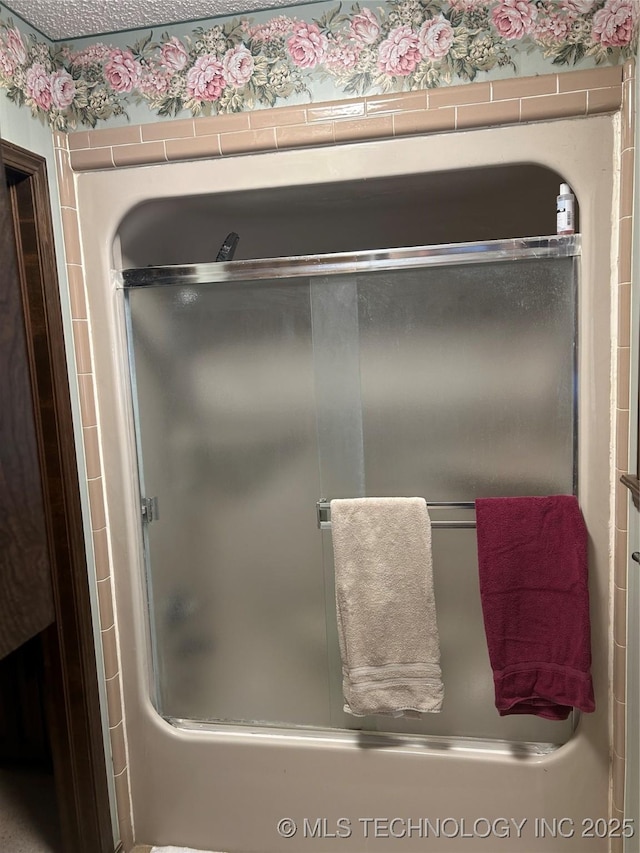 bathroom with shower / bath combination with glass door