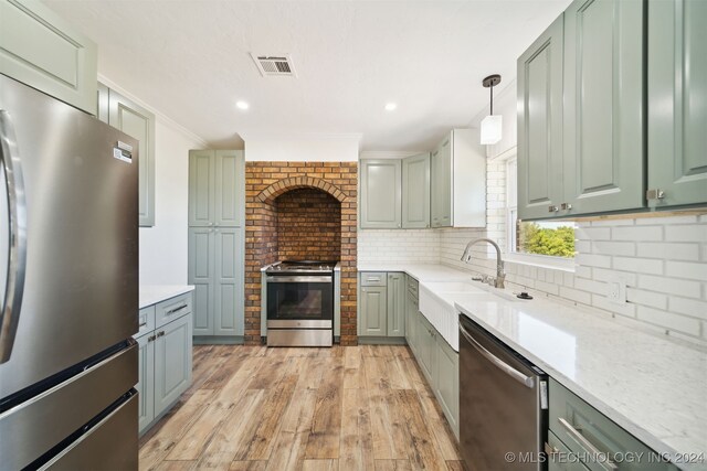 18440 County Road 3564, Ada, OK 74820 - kitchen with appliances with stainless steel finishes, light wood-type flooring, backsplash, green cabinetry, and crown molding