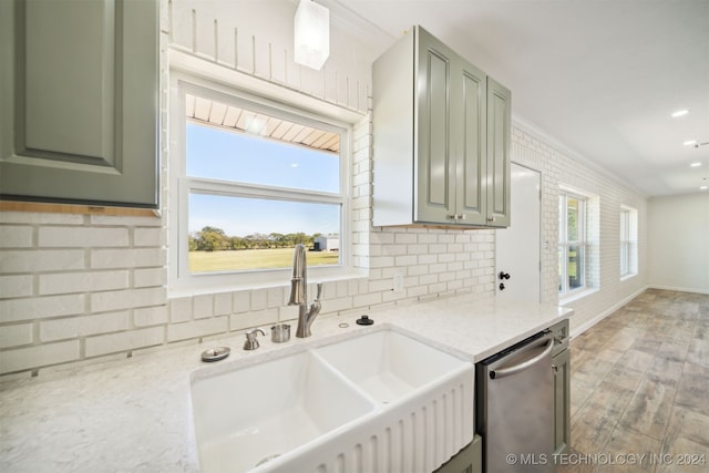 kitchen featuring light stone counters, light hardwood / wood-style floors, dishwasher, and sink