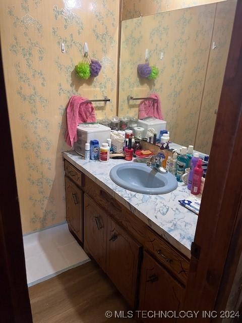 1384 Academy Rd, Bennington, OK 74723 - bathroom featuring wallpapered walls, wood finished floors, and vanity