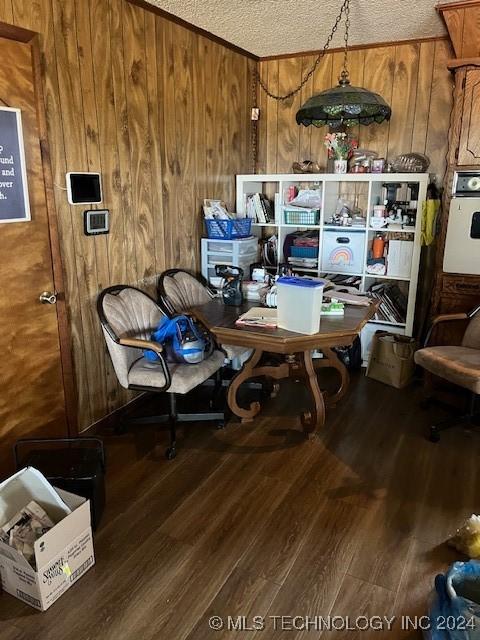 1384 Academy Rd, Bennington, OK 74723 - dining room featuring wooden walls, wood finished floors, and a textured ceiling