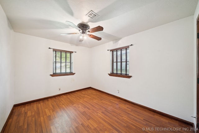 unfurnished room featuring ceiling fan, wood finished floors, and baseboards