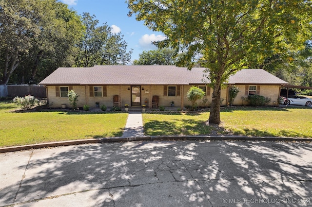 single story home with a front lawn, brick siding, and an attached carport