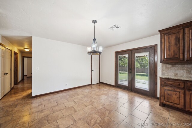 unfurnished dining area with french doors, baseboards, and light stone finish flooring