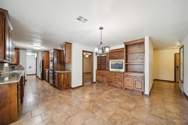 kitchen with baseboards, a chandelier, light stone countertops, black appliances, and pendant lighting