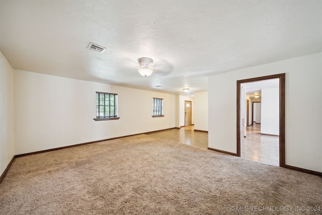 carpeted spare room with baseboards and a ceiling fan