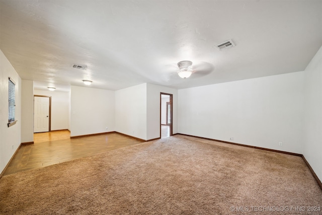 carpeted empty room featuring a ceiling fan and baseboards