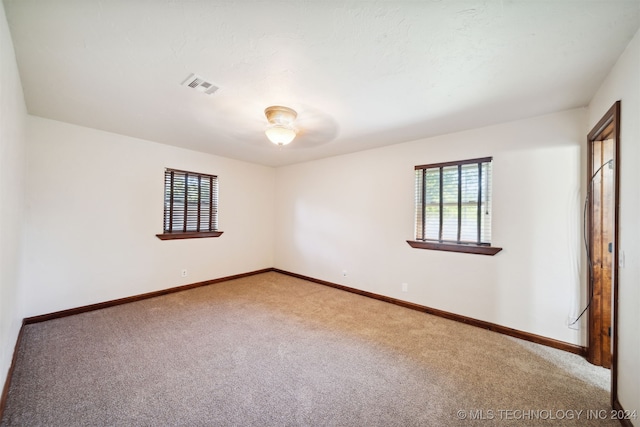 carpeted empty room featuring baseboards