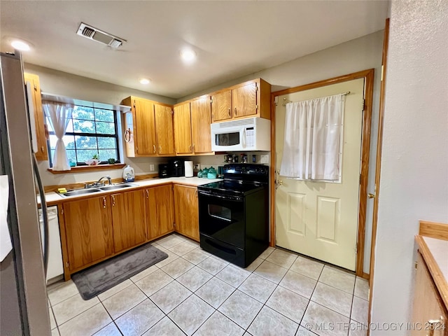 kitchen with light tile patterned floors, sink, and white appliances