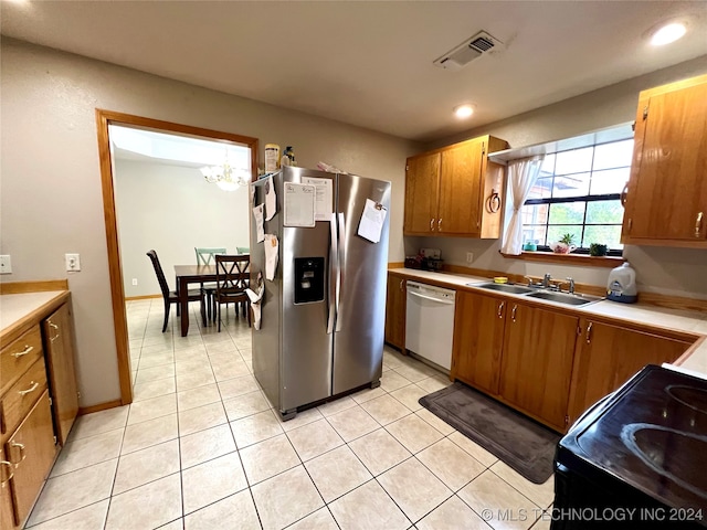 kitchen with black electric range, sink, light tile patterned flooring, white dishwasher, and stainless steel fridge