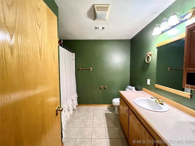 bathroom featuring walk in shower, vanity, tile patterned flooring, and toilet