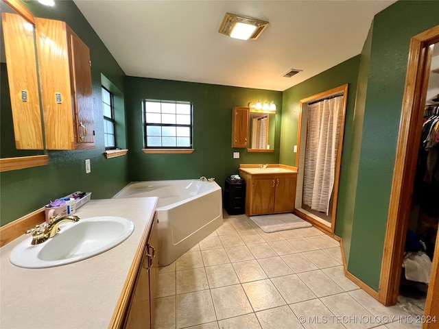 bathroom with vanity, a tub, and tile patterned floors