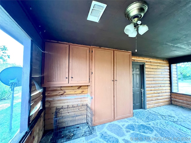 bedroom with rustic walls and multiple windows