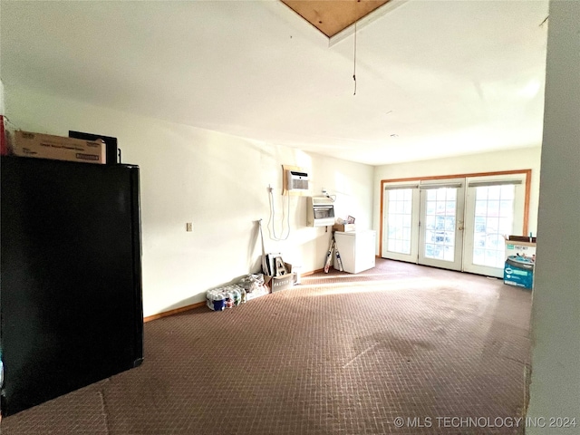 garage featuring black fridge and an AC wall unit