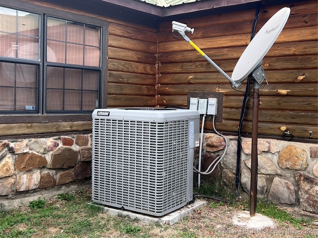 exterior details featuring cooling unit and rustic walls