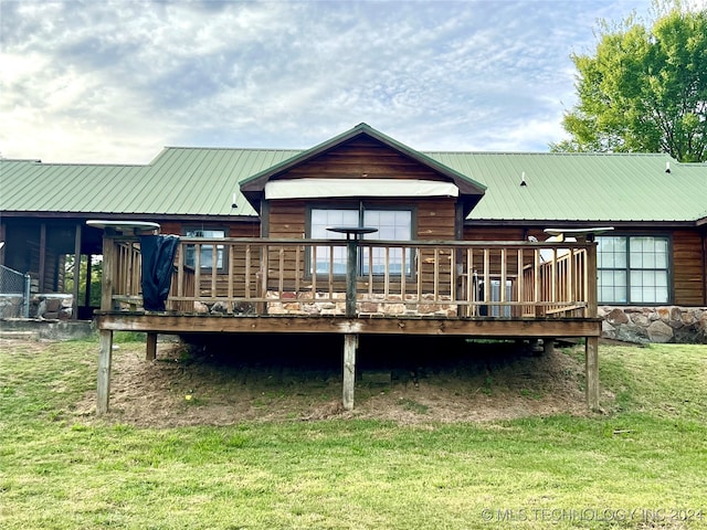 back of property with a lawn and a wooden deck