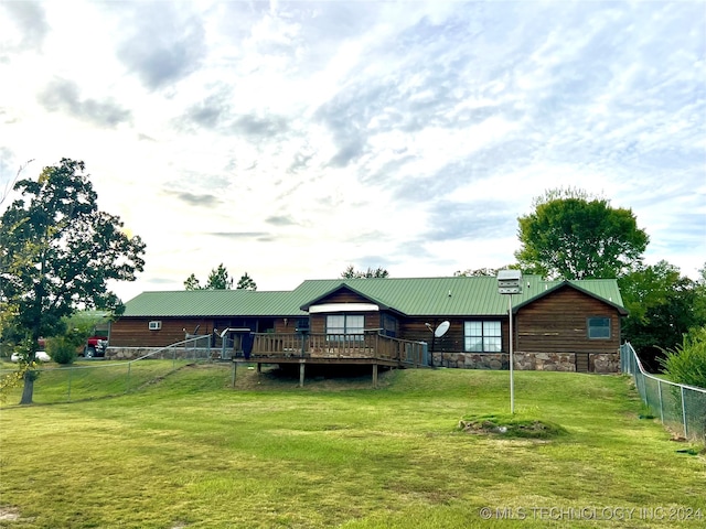 rear view of property featuring a lawn and a deck