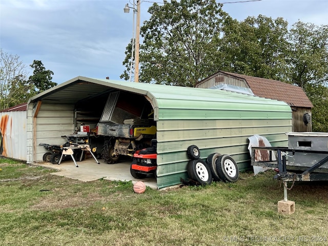 view of outbuilding with a carport and a yard