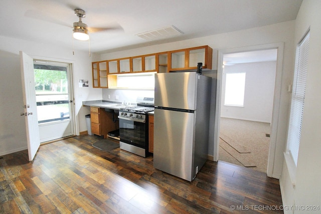 516 W Fox St, Tahlequah, OK 74464 - kitchen with appliances with stainless steel finishes, dark wood-style floors, brown cabinetry, glass insert cabinets, and ceiling fan
