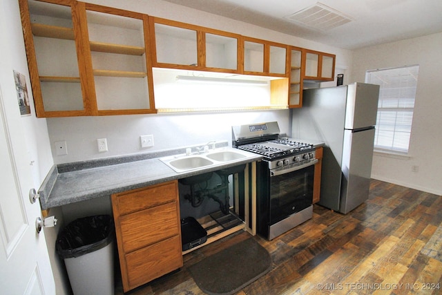 516 W Fox St, Tahlequah, OK 74464 - kitchen with stainless steel gas range, freestanding refrigerator, brown cabinets, dark wood-type flooring, and glass insert cabinets