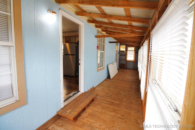 hallway with hardwood / wood-style floors and lofted ceiling with beams