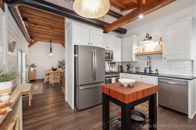 kitchen featuring stainless steel appliances, white cabinets, beamed ceiling, and sink