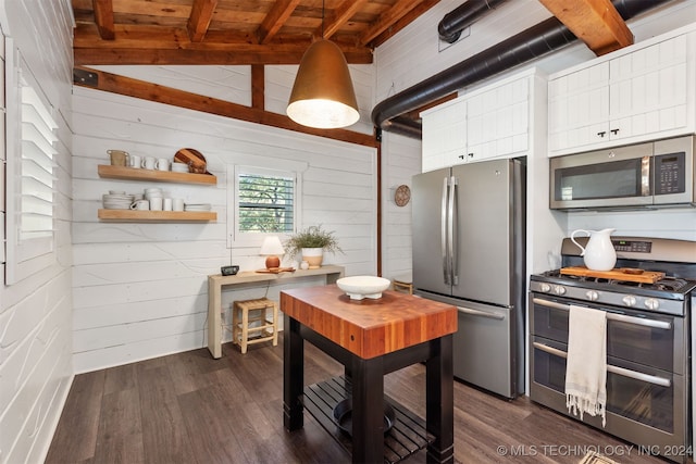 kitchen with wood ceiling, dark wood-type flooring, stainless steel appliances, vaulted ceiling with beams, and wooden walls