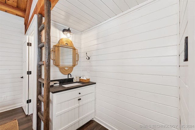 bathroom featuring wooden ceiling, wooden walls, vanity, and hardwood / wood-style flooring